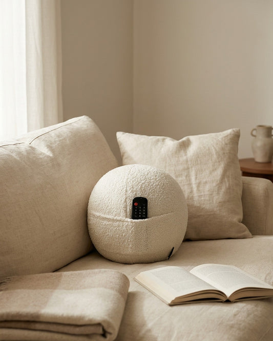 COZELA Orb white bouclé sphere pillow styled on modern sectional sofa with book